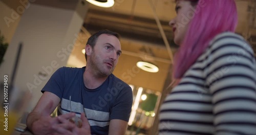 Model engages in lively conversation at urban cafe during afternoon gathering with friends