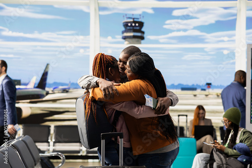 Tableau sur toile Emotional scene of African American parents hugging daughter in airport terminal, saying bittersweet goodbye before departure flight, Young traveler leaving to study abroad, solo travel