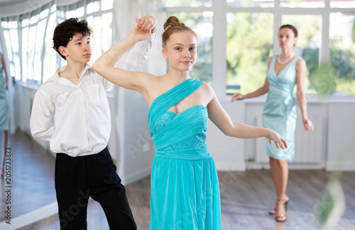 Fotografía Young of teenagers in evening dresses are learning to dance an polonaise dance