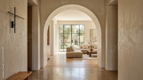 Spacious living room viewed through curved archway with natural light and minimalist decor