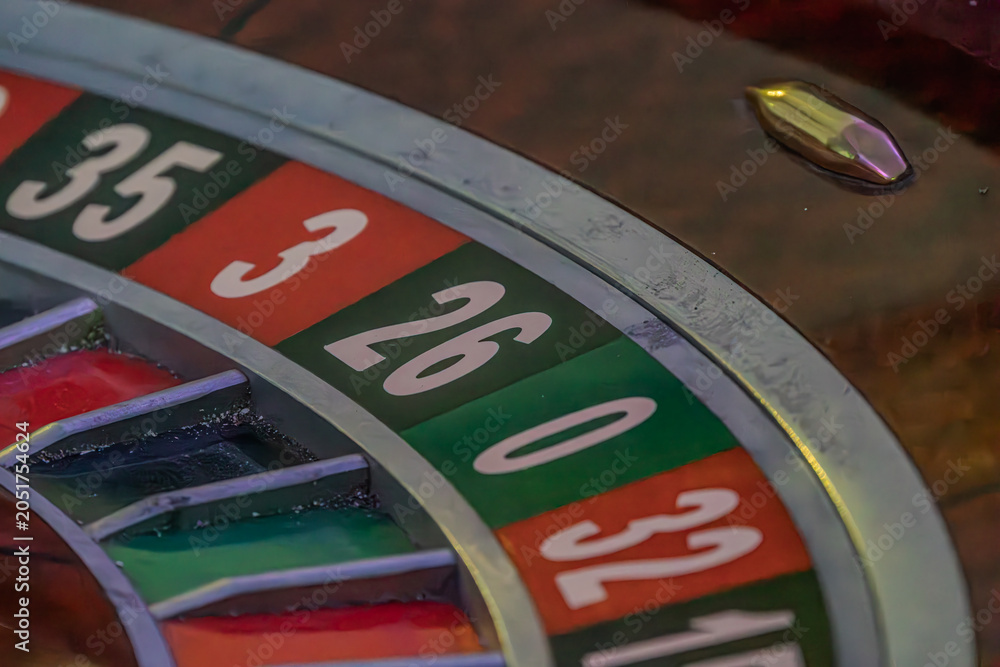 Obraz premium Close-up view of a lit roulette wheel with alternating red and black numbered slots Perspective from above, no additional context or embellishment