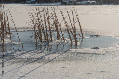 Bild auf Leinwand Winter scene of a frozen lake, covered in snow Snow-covered ground with varying