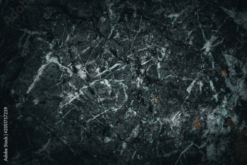 Dark and moody high-key macro close-up of abstract black marble texture with subtle white veins in stone