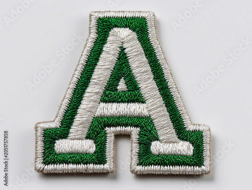 Close-up of a stitched, kelly green A on white background Embroidered design in collegiate style - AI-Generated