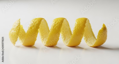 Vibrant yellow lemon zest curls arranged neatly on a polished white surface, highlighting natural texture and bright color in soft light, culinary, raw, tangy