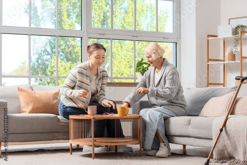 Fotografie Senior woman with dementia and her daughter doing puzzle at home