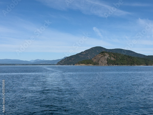 Scenic view of ocean and forest covered mountains on the coast