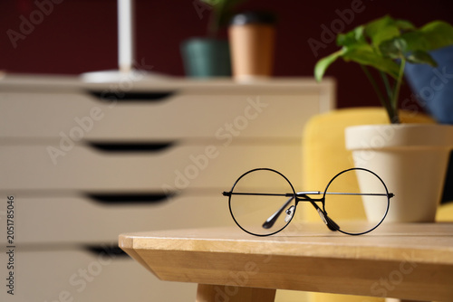 Canvastavla Stylish round eyeglasses on table in room, closeup
