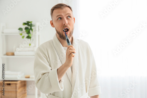 Young bearded man brushing ...