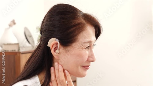 補聴器を付けたシニア女性　リビング