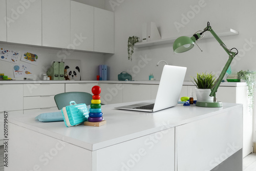 Pediatrician's workplace with laptop and lamp in office