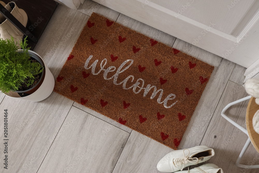 Fototapeta premium Doormat with winter shoes and Cypress tree in hallway, top view