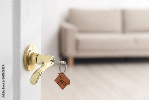 Open door with key in rented apartment, closeup