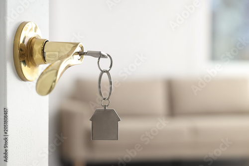 Open door with key in rented apartment, closeup