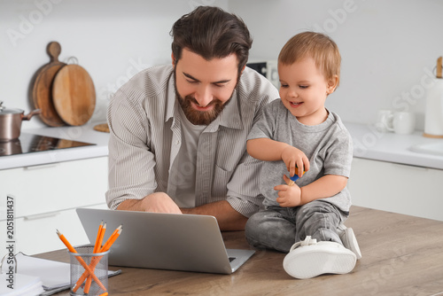 Father working with laptop ...