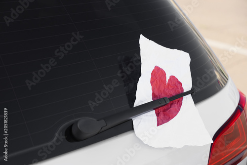 Fotografie Sheet of paper with heart behind rear window wiper, closeup