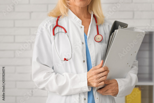 Female doctor with folders in clinic, closeup