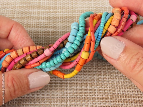 Canvastavla Closeup of woman hands holding colorful strings of beads for bijouterie or jewelry