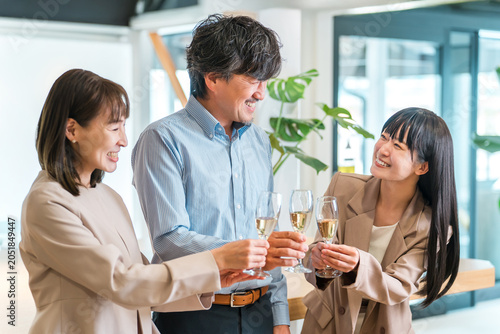 Foto Businessmen and businesswomen line up in the office with champagne bottles (team