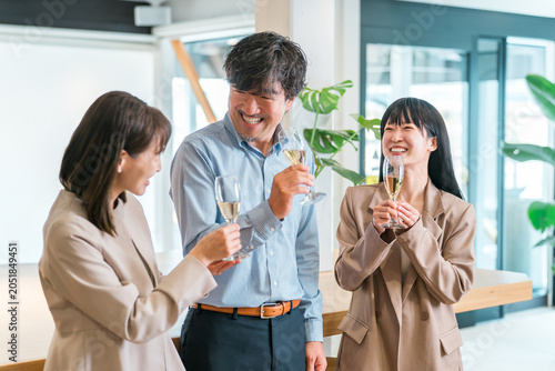 Fotografi Businessmen and businesswomen line up in the office with champagne bottles (team