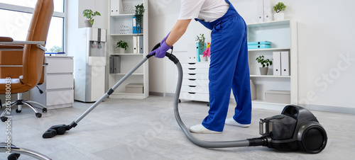 Janitor vacuuming floor in ...