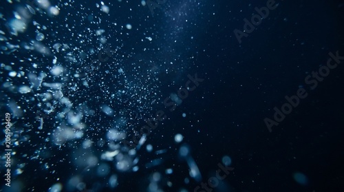 Foto Deep-sea particle drift with glowing plankton and organic microparticles floatin