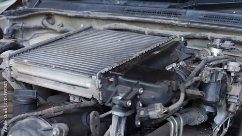 Old intercooler. A dirty intercooler with engine oil stains installed on a diesel engine during repairs in a garage. Car maintenance concept with copy space with selective focus.