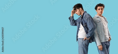 Photos Young men in denim jackets standing back to back, one thoughtful and one confide