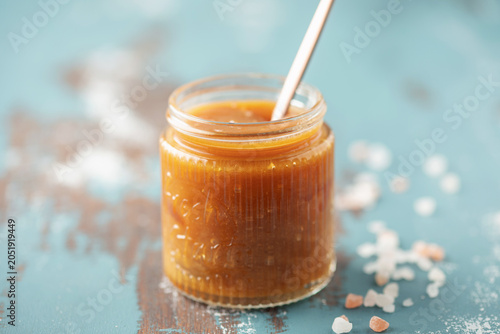 Quadro su tela Glass jar with salted caramel and spoon on the table