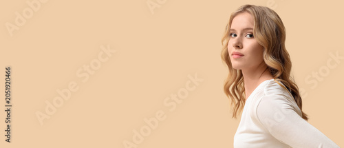 Canvastavla Blonde young woman with curly hair on beige background