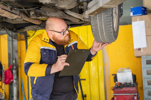 Tire inspection action by mechanic in auto shop detailed checklist review professional environment close-up view