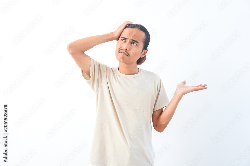 Naklejka premium Young Asian man in a shirt, with a confused face expression. Isolated on a white background