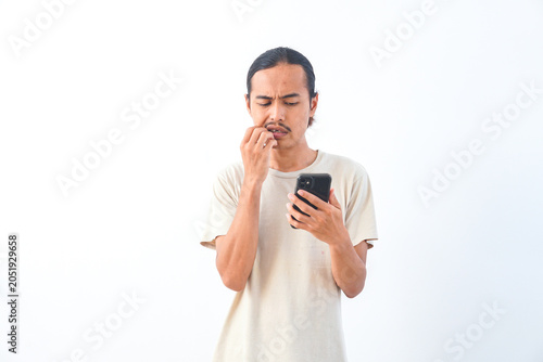 Bild auf Leinwand Young Asian man in a shirt, with a confused face expression