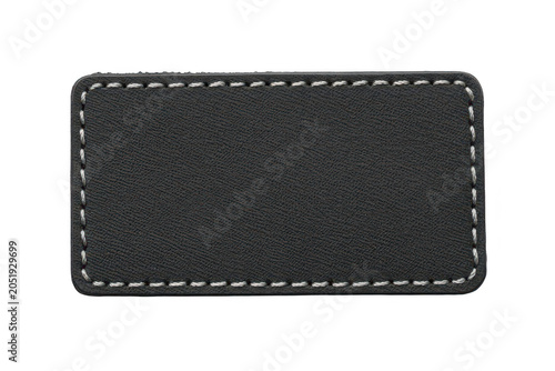 A rectangular black leather patch with white stitched borders, isolated on a black background, for clothing and, textile applications