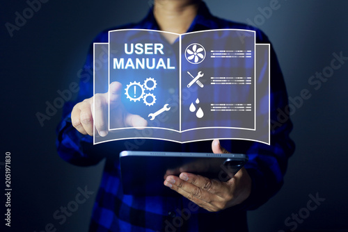 Person holding a tablet and pointing at a virtual digital user manual book interface in technical symbols for maintenance, troubleshooting and devices operations