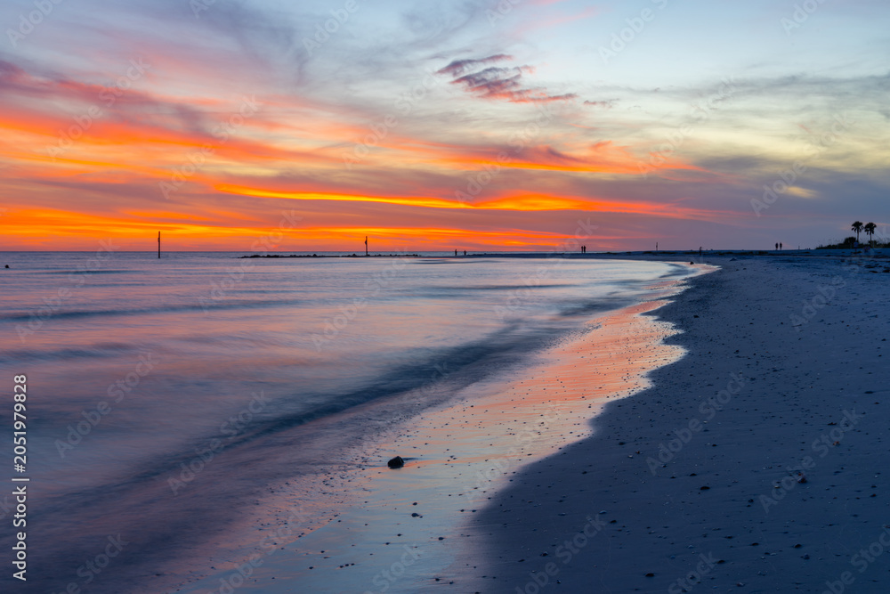 Obraz premium Seascape. Colorful beach sunset with vibrant orange and pink clouds reflected on calm ocean water. Peaceful sandy shoreline at dusk, tropical coastal landscape. Scenic nature. Travel destination