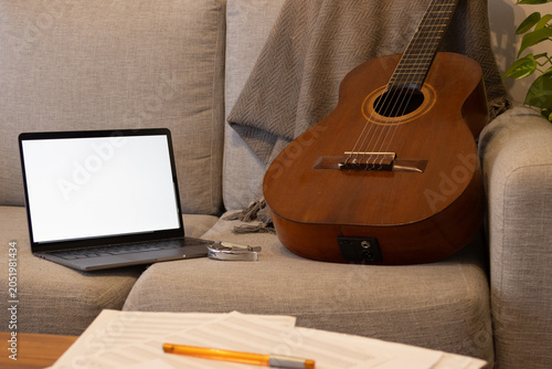 Konstfotografi Living room home studio with open laptop, acoustic guitar, capo and sheet music