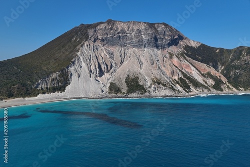 Aerial drone photo of Satoyama volcano and turquoise bay at Kozushima Island, Tokyo, Japan