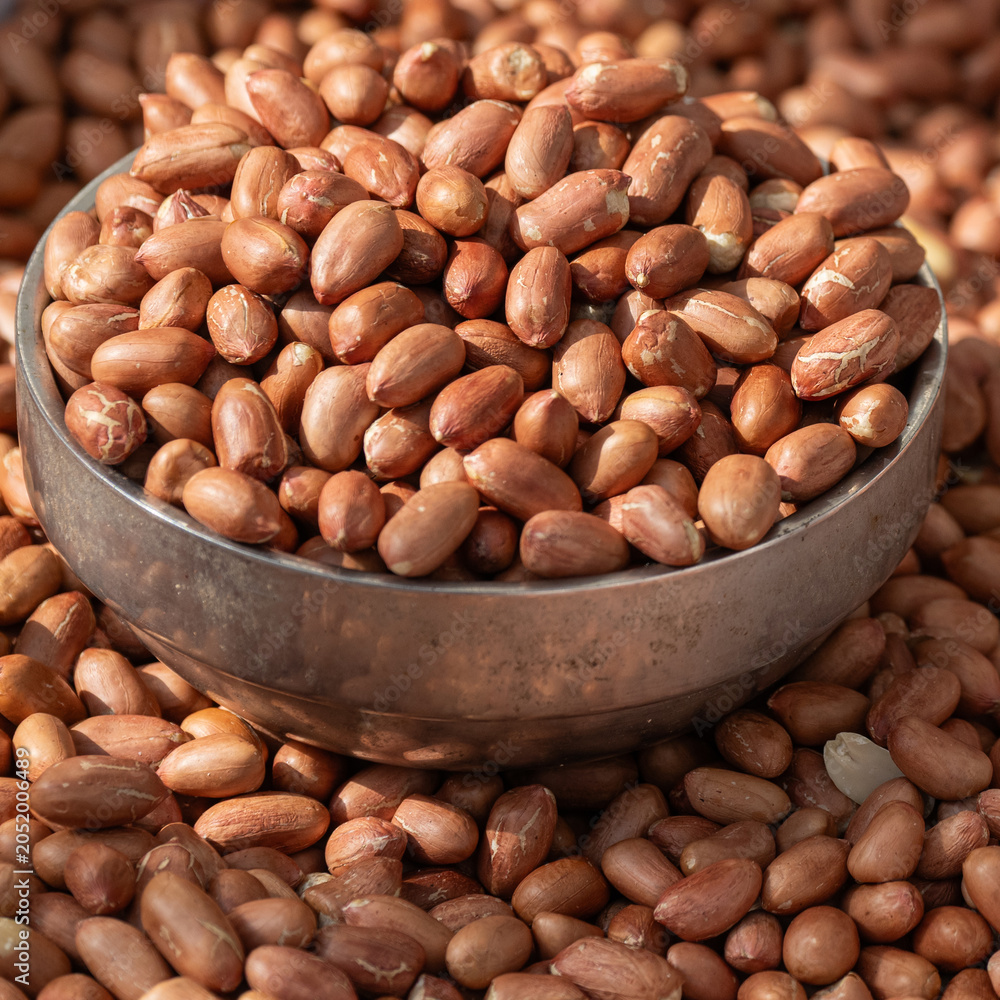 Obraz premium Close up of raw peanuts filled in metal bowl at South Korea traditional market.