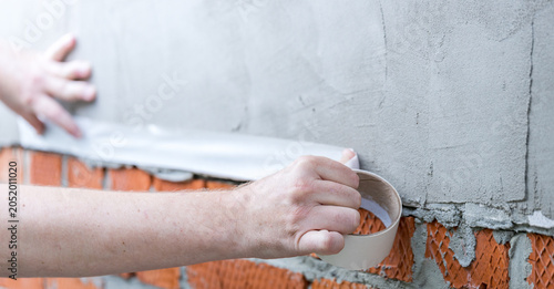 Photos Hands apply waterproof sealant to brick wall joint