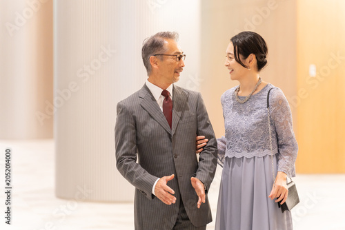 Canvastavla ホールの前に立つフォーマルな中高年夫婦