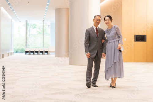 Canvastavla ホールの前に立つフォーマルな中高年夫婦