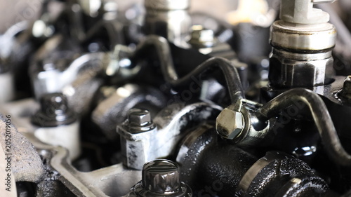 Common rail fuel injector set. Close-up of high pressure pipe of dirty fuel injector assembly on diesel engine cylinder head during repair in garage with selective focus.