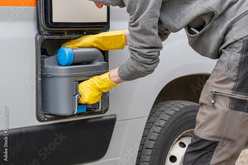 Emptying portable cassette toilet from campervan during campsite sanitation maintenance