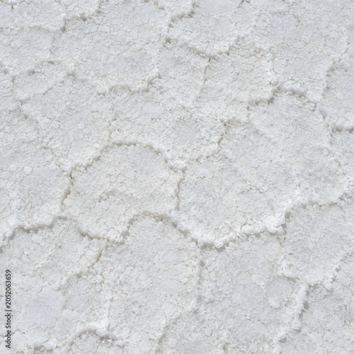 Detailed close up view of the textured white salt crust patterns covering the vast surface of the famous bolivian salt flats under bright natural daylight