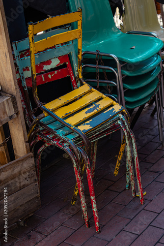 Colorful Vintage Metal Chairs and Stacked Plastic Seats on Outdoor Café Terrace