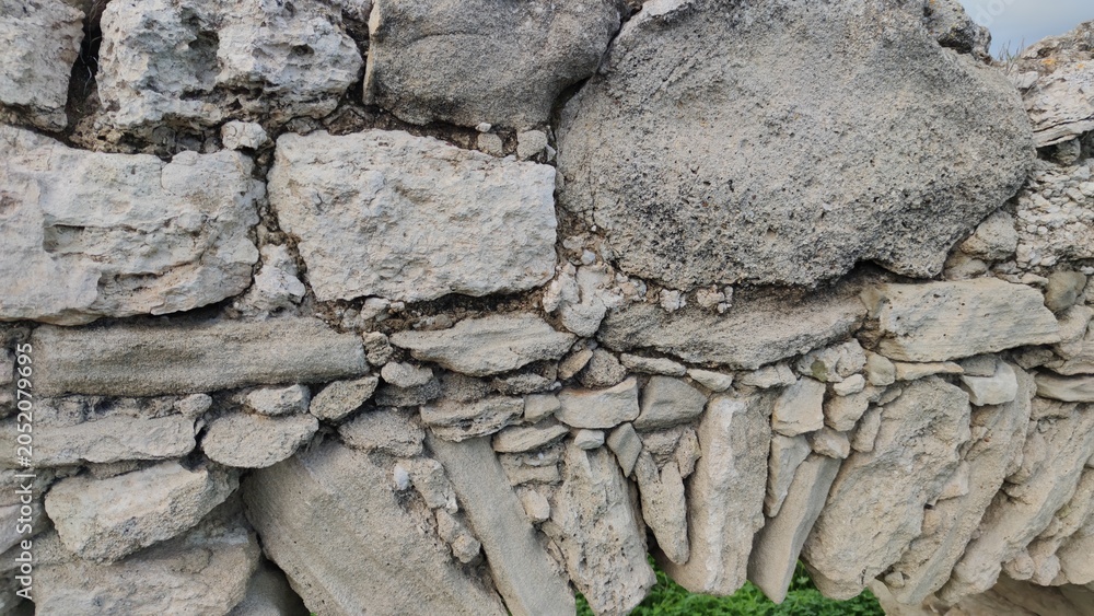 Fototapeta premium Detailed macro shot focusing on the weathered rocks, traditional mortar, and historic masonry structure of an old stone aqueduct wall.