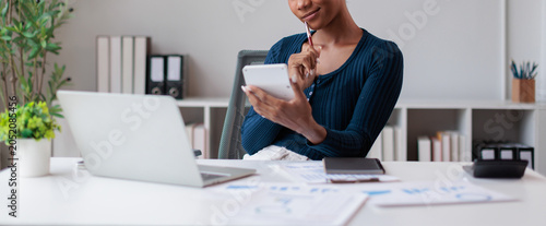Принти на полотні Black woman finding solutions at desk, calculating finances, managing budget, pl