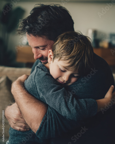 Father son hug family bond parental love emotional moment tender embrace cozy home childhood comfort trust closeness support care affection