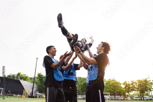 Photos Soccer team tossing teammate in the air to celebrate victory